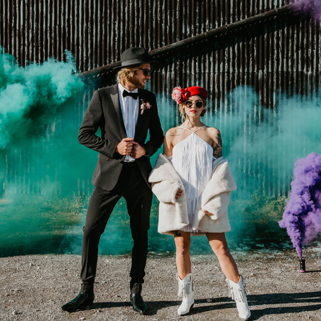Wedding couple surrounded by green and purple smoke